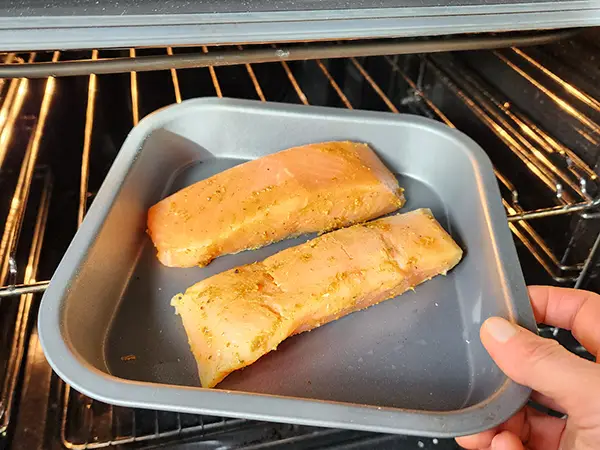 Putting salmon to the oven to bake