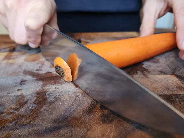 Trimming off the stem from a carrot with a chef's knife