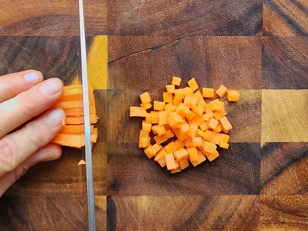 Dicing carrots on a wooden board