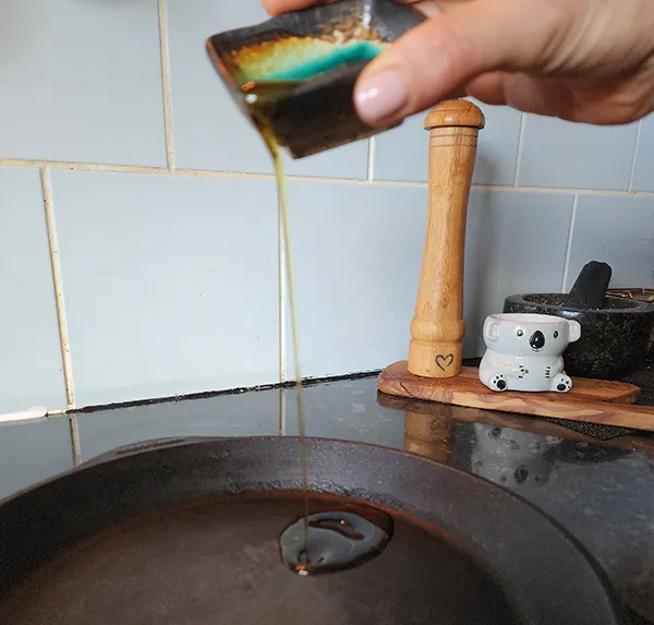 Poring olive oil to a skellet