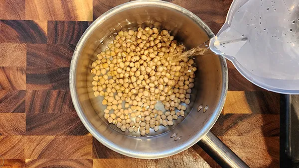 Covering chickpeas in a pot with water