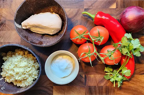 Chicken salad stuffed tomato ingredients on the wooden board