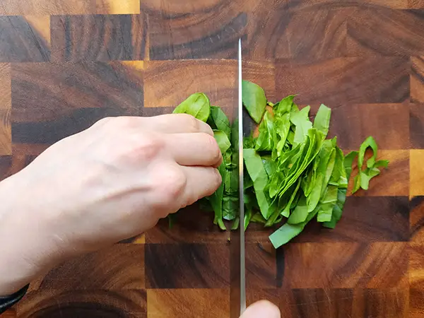 Chopping spinach on th ewooden board