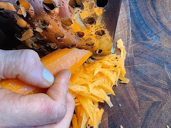 Grating a carrot on a wooden board