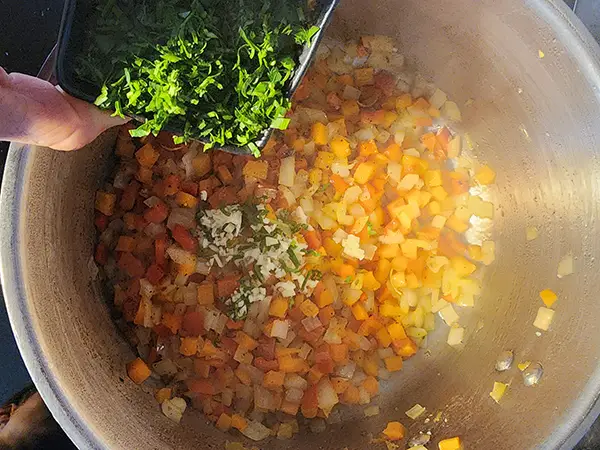 Adding fresh parsley to the lentil soup