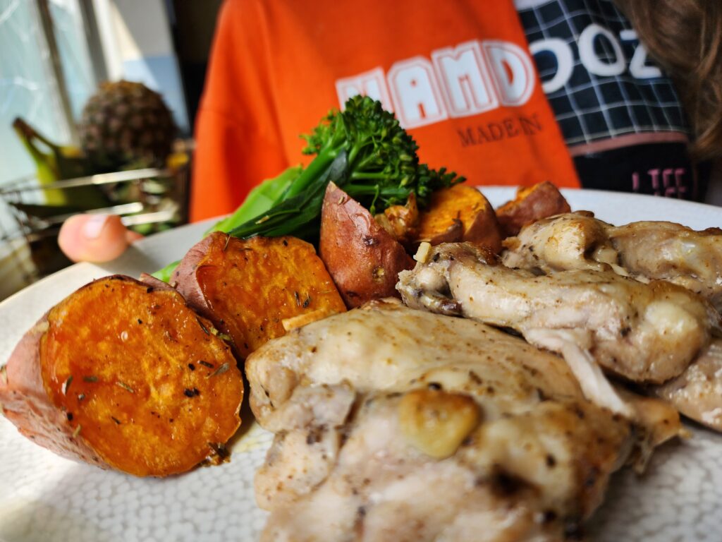 Serving chicken thigs, sweet potatoes and broccoli