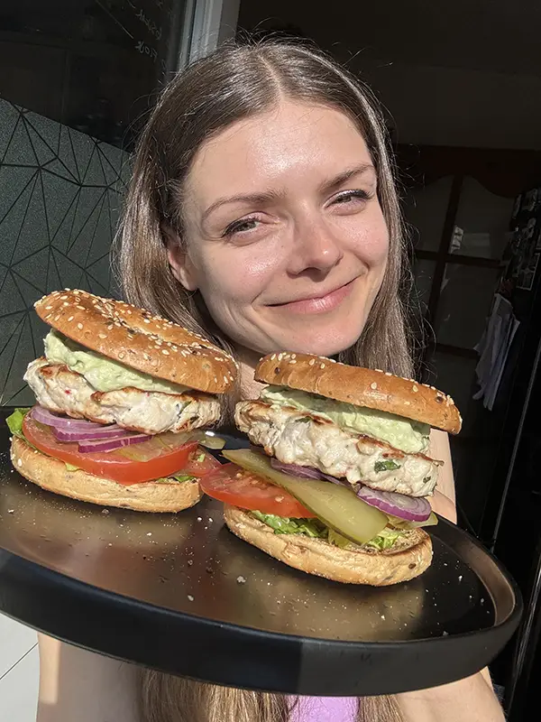 Woman holding a plate with two chicken burgers